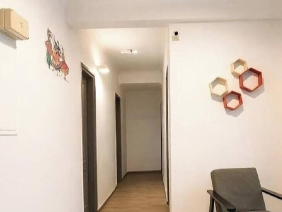 A hallway with a chair, a door, and hexagonal wall decorations.