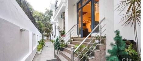 A narrow pathway leading to a building with a staircase and a door labeled "Other".
