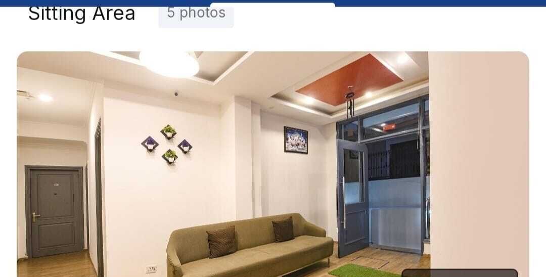 Espaço de estar com sofá, porta e decoração fixada na parede.