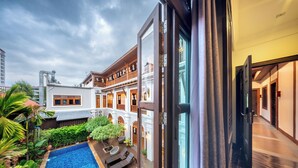A hotel with a swimming pool, outdoor seating, and a traditional architectural style. - At Tree Hotel Thaphae Gate Chiangmai (Chiang Mai)