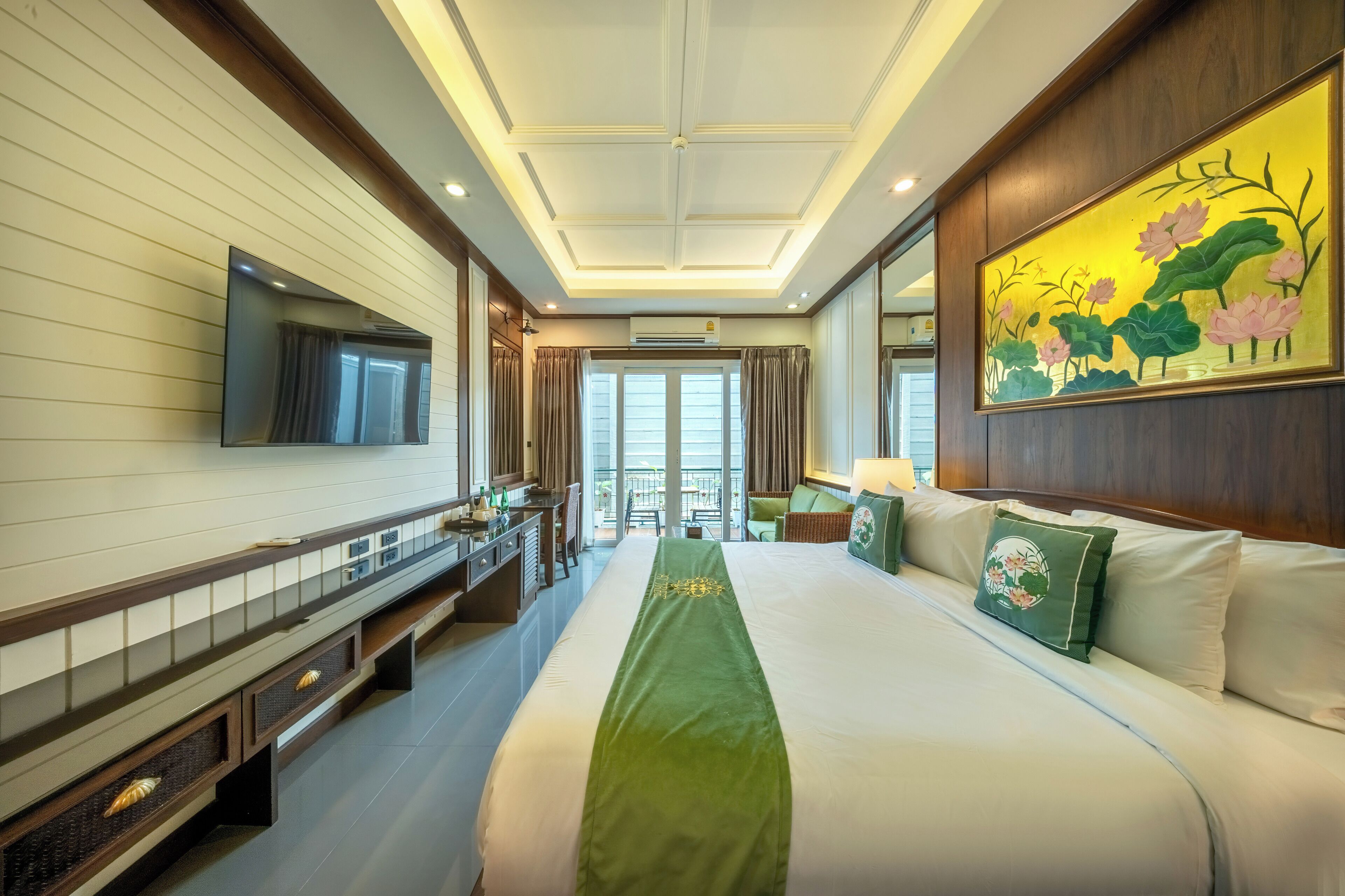 A hotel room with a large bed, a flat-screen TV, a desk with drawers, a window, and a painting on the wall.