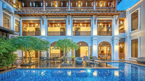 A multi-story building with a central pool, balconies, and traditional architectural elements. - At Tree Hotel Thaphae Gate Chiangmai (Chiang Mai)