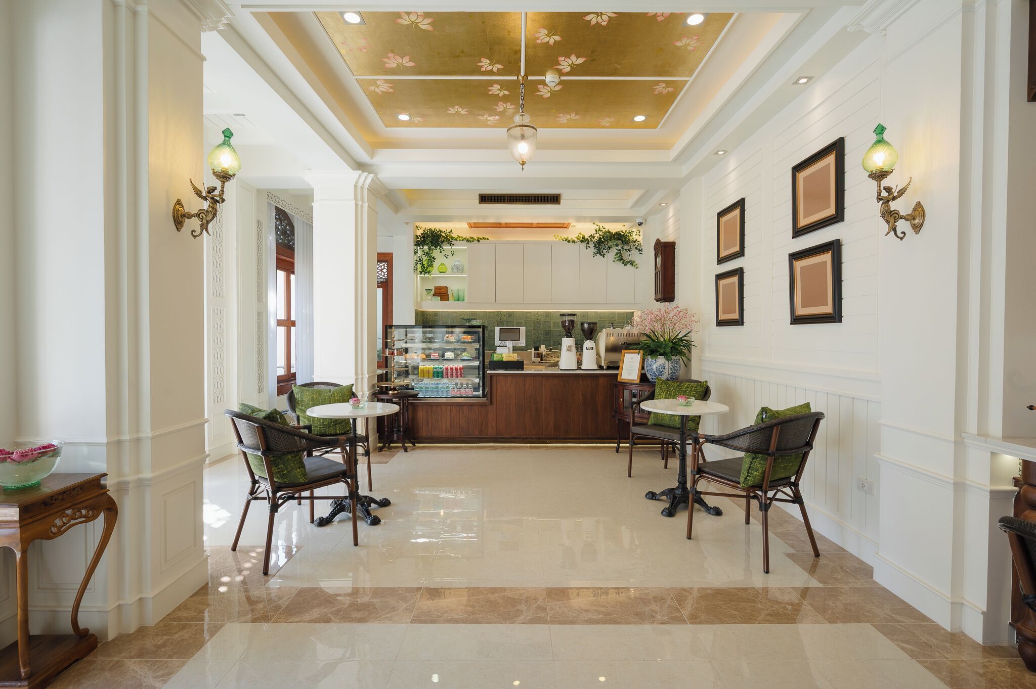 A spacious lobby with a polished floor, a reception desk, and a seating area with chairs and tables.
