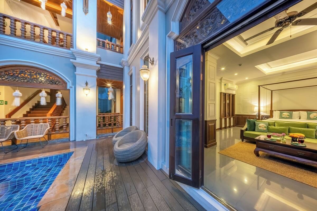 Un hall d’hôtel avec une piscine, un escalier et un espace salon.