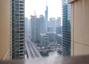 A high-rise building with a view of a busy road and a body of water. - Stayshort - Chic Apartment in JBR Sleeps 3 With Canal View (Dubai)