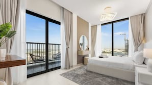 Ein modernes Hotelzimmer mit großem Balkon, einem Bett, einem Nachttisch und Blick auf die Stadt.
