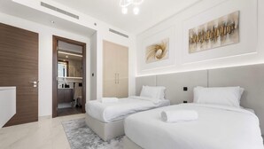Ein modernes Hotelzimmer mit zwei Betten, einem großen Spiegel und einem minimalistischen Design.