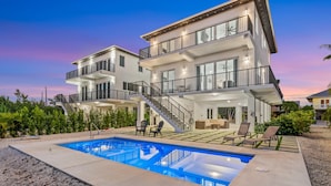 A modern multi-story house with a swimming pool, outdoor seating, and a staircase leading to the upper levels. - Isla Luna Waterfront Oasis Pool Dock Kayaks (Marathon)