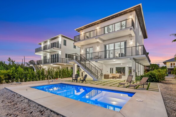 A modern multi-story house with a swimming pool, outdoor seating, and a staircase leading to the upper levels. - Isla Luna Waterfront Oasis Pool Dock Kayaks (Marathon)