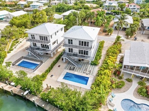 A two-story beachfront property with a swimming pool, a dock, and a landscaped garden. - Isla Luna Waterfront Oasis Pool Dock Kayaks (Marathon)