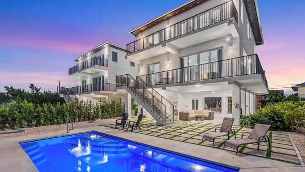A modern two-story house with a swimming pool, outdoor seating, and a staircase leading to the upper floor. - Isla Luna Waterfront Oasis Pool Dock Kayaks (Marathon)