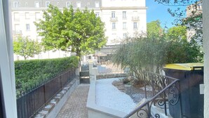 A courtyard with a tree, a paved pathway, and a building with a sign that reads "Continental." - Amazing Holiday Home in the Heart of Vittel (Vittel)