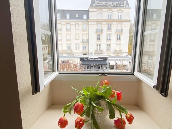 A window with a view of a building labeled 'CONTINENTAL' and a restaurant named 'Le Barbouille' across the street. - Amazing Holiday Home in the Heart of Vittel (Vittel)