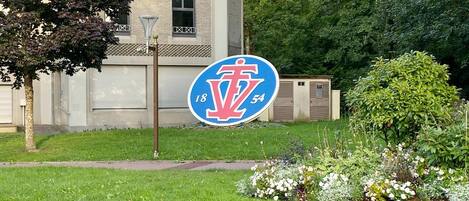 En bygning med et blåt og hvidt skilt, der viser et rødt 'V' og tallene '18' og '54'.