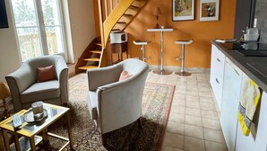 A modern living room with a sofa, a coffee table, and a patterned rug. A staircase leads to an upper level. - Amazing Holiday Home in the Heart of Vittel (Vittel)