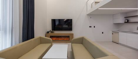 A modern living room with a sofa set, a flat-screen TV, and a fireplace.