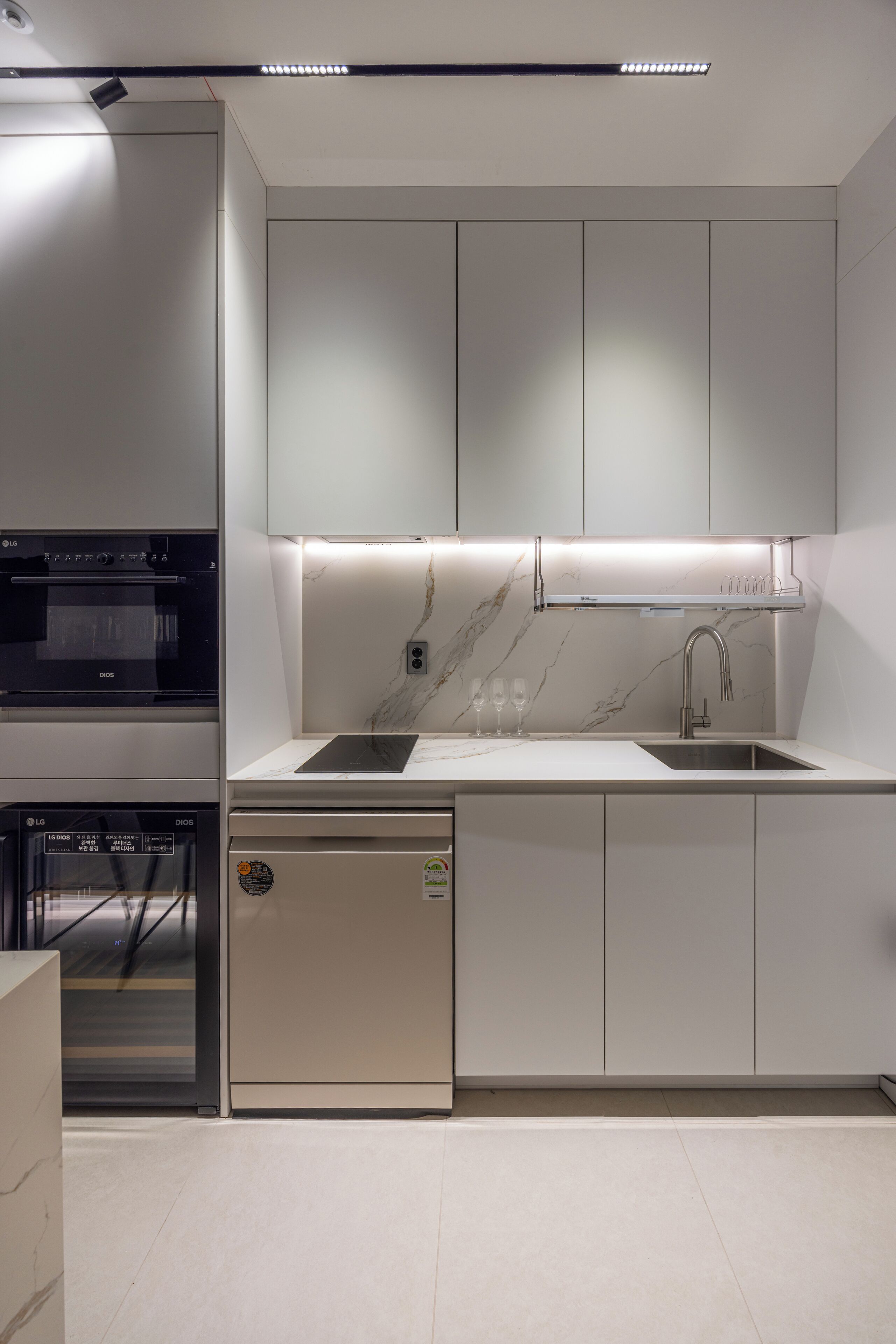 Una cocina moderna con electrodomésticos integrados, un protector contra salpicaduras de mármol y un diseño elegante.