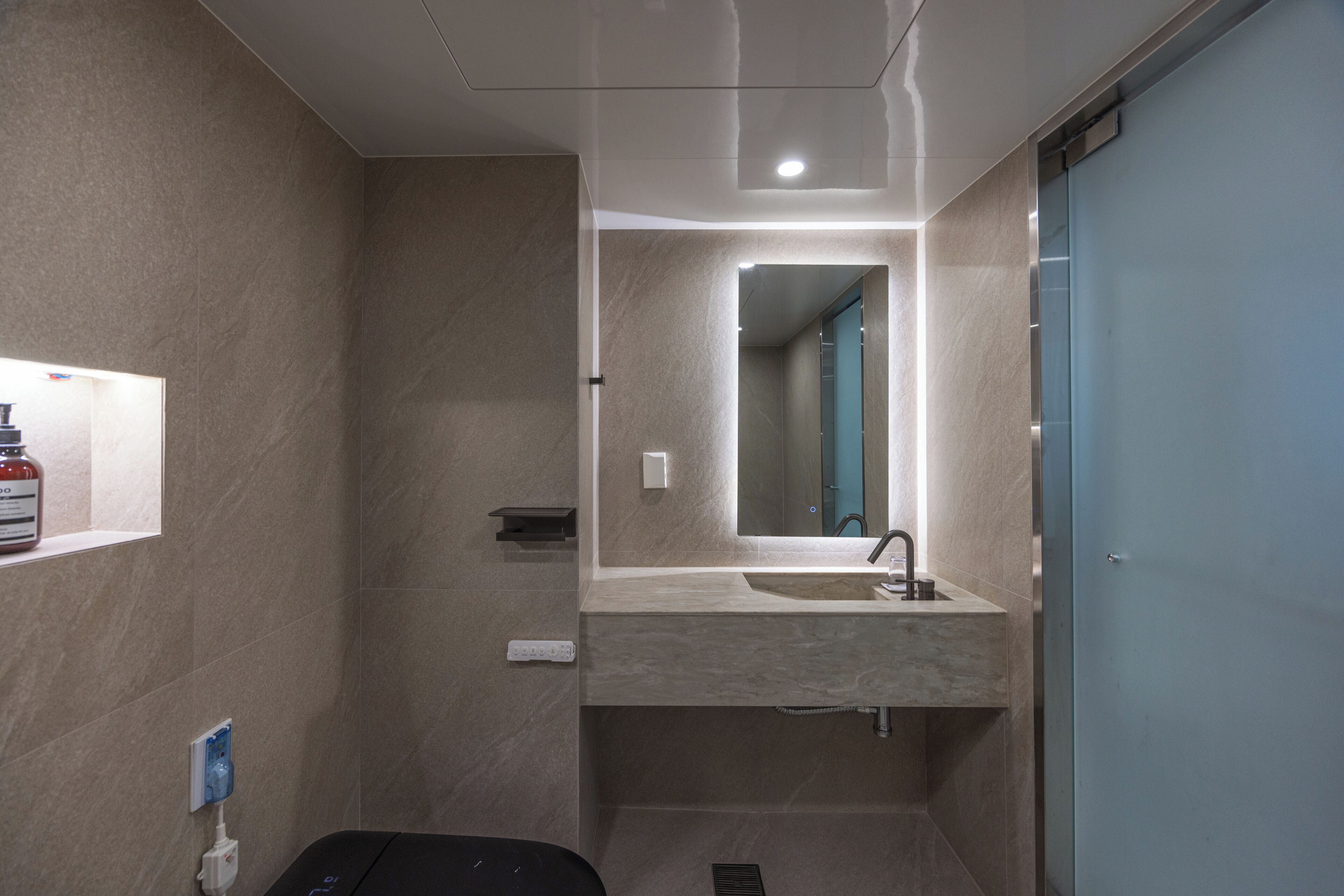 Une salle de bain moderne avec un grand miroir, un lavabo et des toilettes.