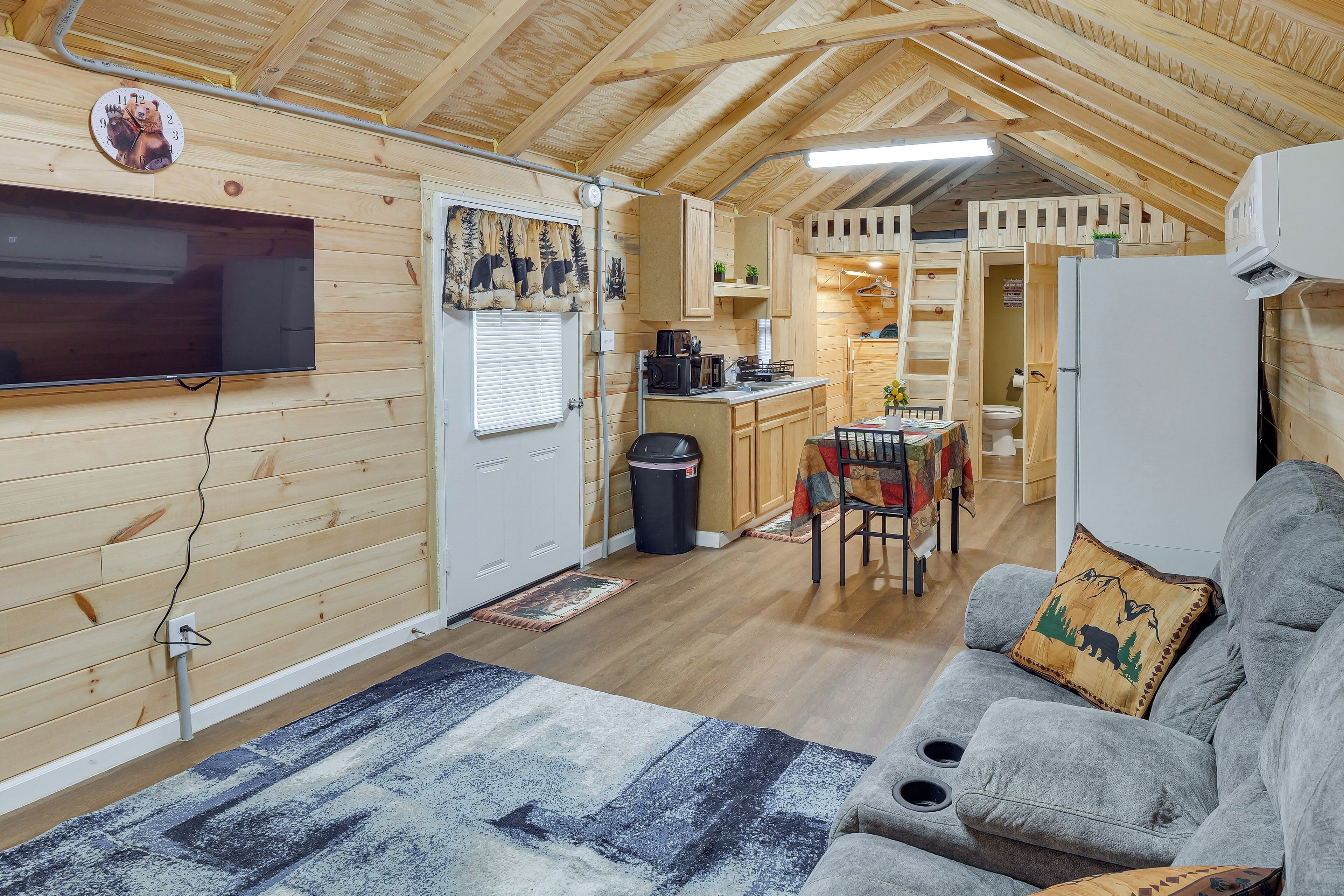 Interior acogedor de una cabaña con sala de estar, kitchenette y comedor.