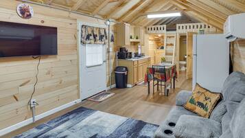 Interior acogedor de una cabaña con sala de estar, kitchenette y comedor.