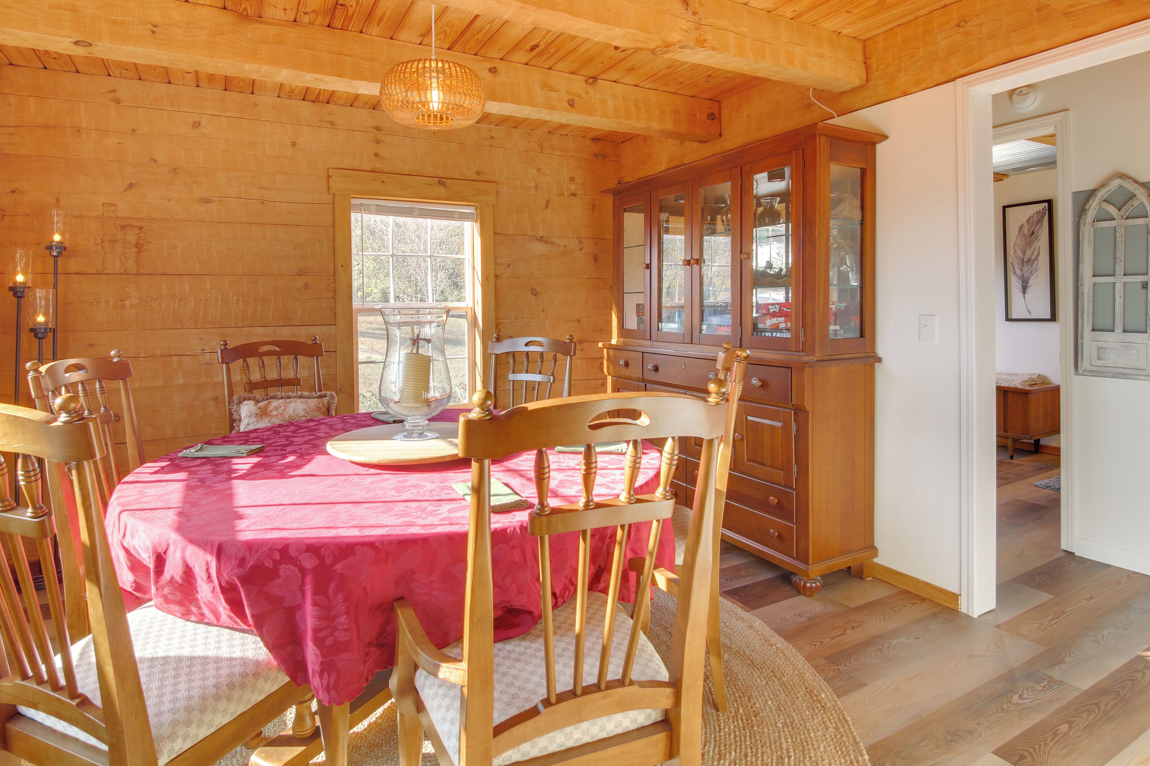 A dining area with a wooden table and chairs, a cabinet, and a window with natural light.
