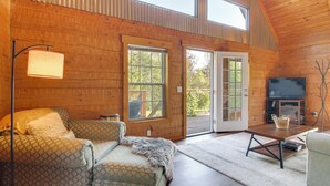 A cozy cabin interior with a wooden interior, a sofa, a coffee table, and a television. - Hike & Unwind, Peaceful Wooded Retreat in Newport (Newport)