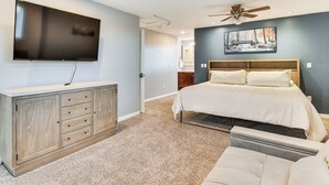 A bedroom with a bed, a TV mounted on the wall, a ceiling fan, and a painting above the bed. - Mountain-view Retreat w/ Hot Tub in Centerville! (Centerville)