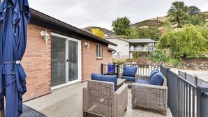 A patio with wicker furniture, a sliding glass door, and a view of a hillside. - Mountain-view Retreat w/ Hot Tub in Centerville! (Centerville)