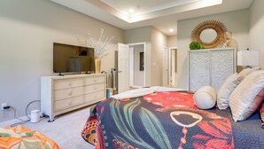 Ein Schlafzimmer mit Bett, Kommode, Schminktisch und Spiegel.