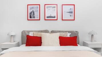 A neatly arranged bedroom with a bed, pillows, and bedside tables.