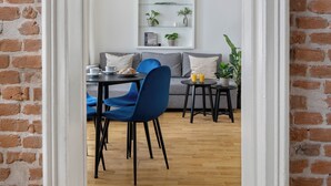A room with a brick wall, a white door, a dining table with chairs, and a sofa. - Enjoy Downtown Boutique Apartments #12 by Goodnite cz (Brno)