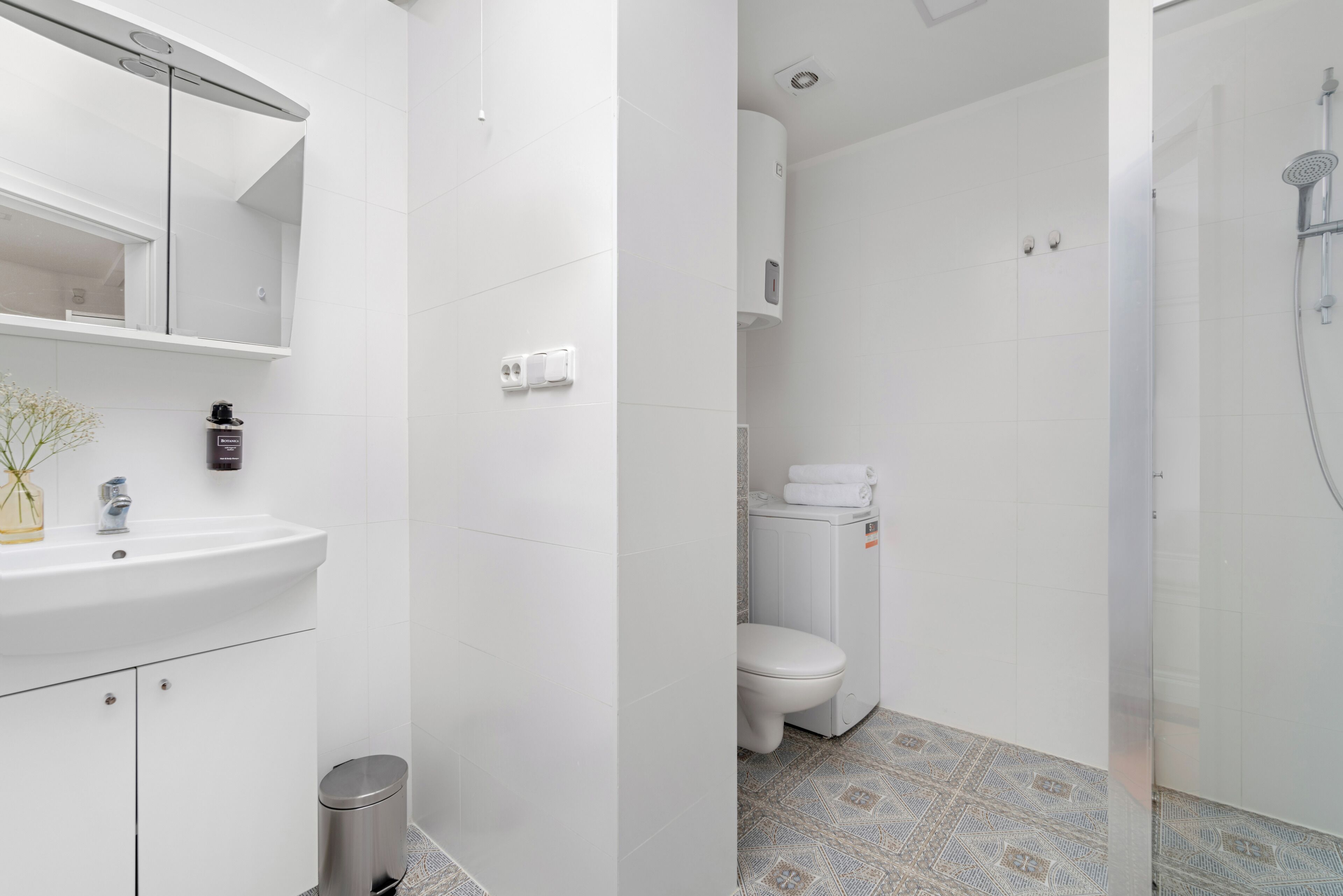 Un baño con lavamanos, espejo y retrete.