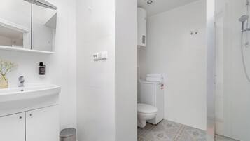 Un baño con lavamanos, espejo y retrete.