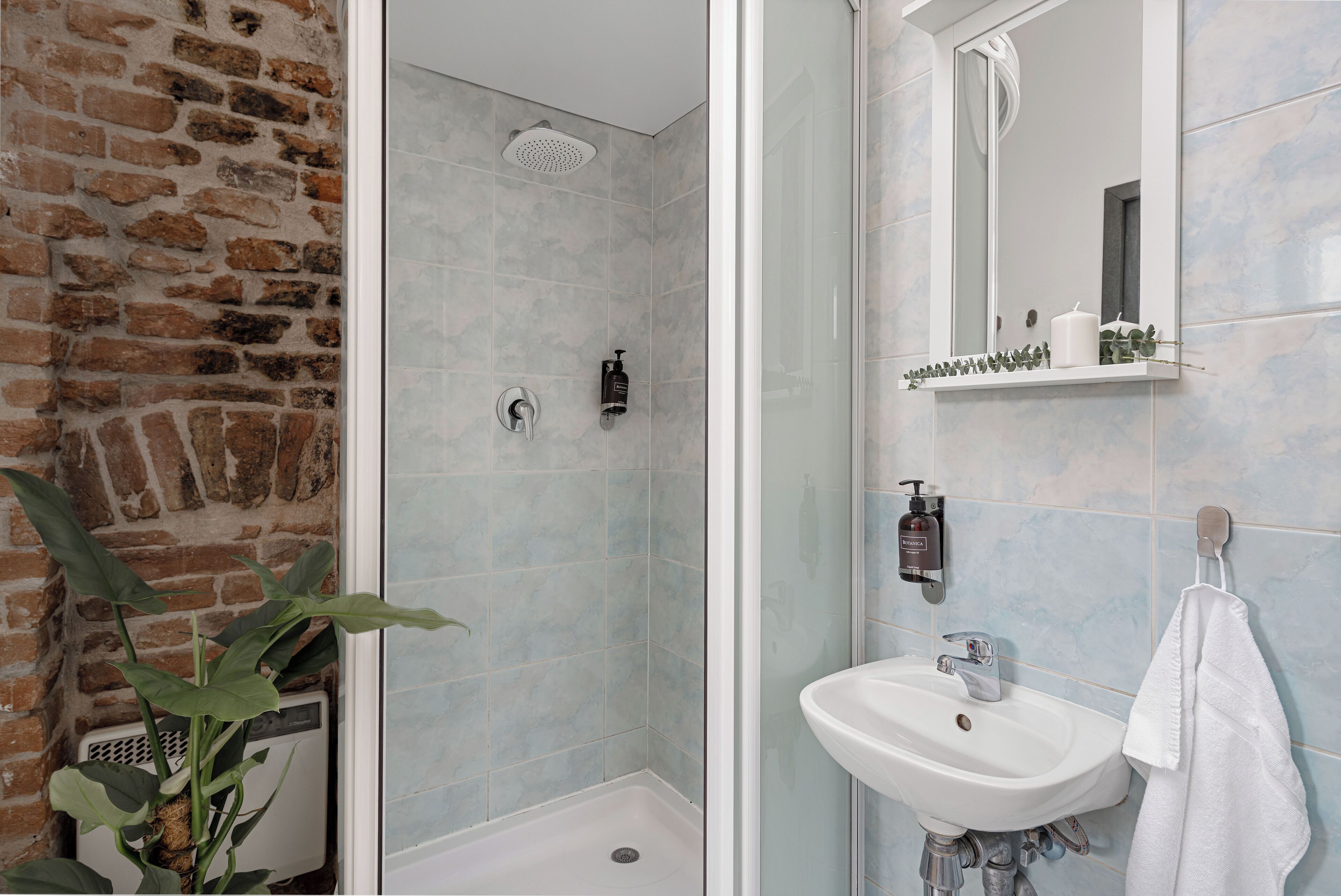 Ein Badezimmer mit Dusche, Waschbecken und Spiegel.