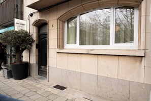 Un edificio con un'ampia pianta in vaso, una finestra con cornice bianca e una porta con il numero 5 sopra.