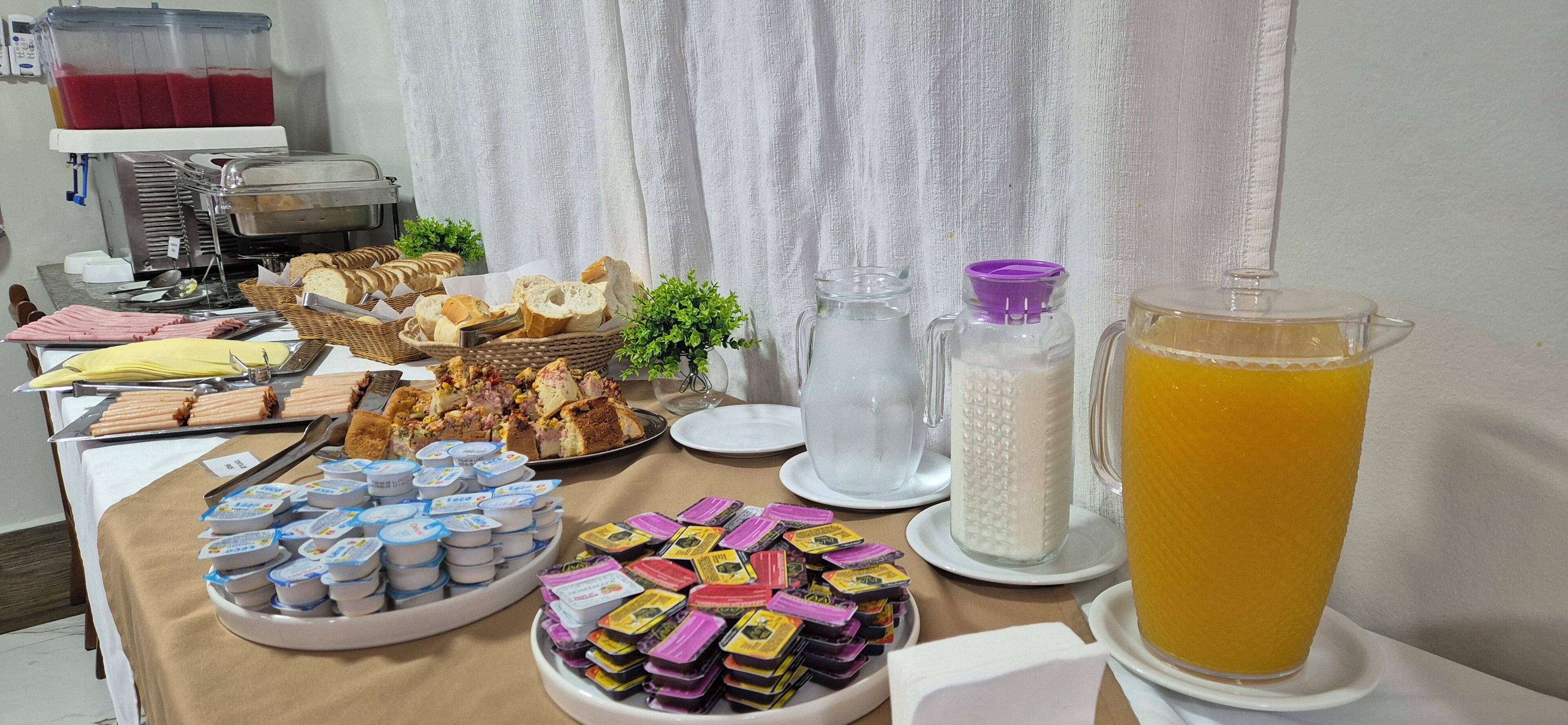 Una mesa de buffet con diversos alimentos, como pan, pasteles y productos lácteos.