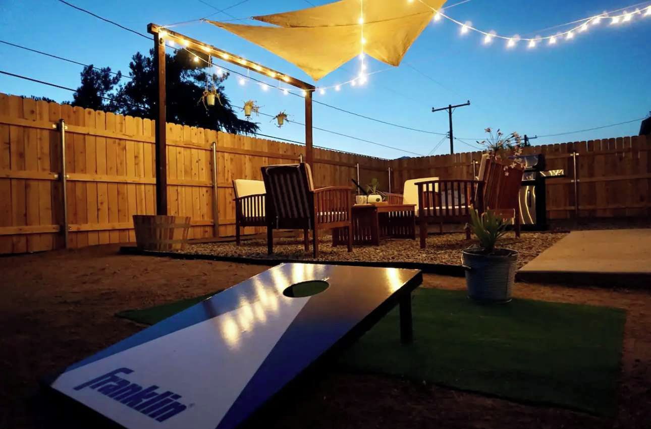 A backyard with a wooden fence, outdoor furniture, a table, and a game table labeled 'Franklin'.