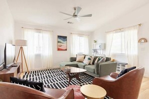 A modern living room with a sofa, armchairs, a coffee table, and a floor lamp. - Kid-Ready Retreat: Lake Isabella Fun (Lake Isabella)