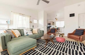 A modern living room with a green sofa, a brown leather armchair, and a black and white rug. - Kid-Ready Retreat: Lake Isabella Fun (Lake Isabella)