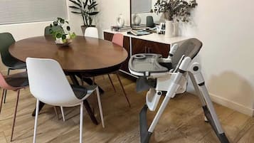 En matplats med ett runt bord, stolar och en eldriven rullstol.