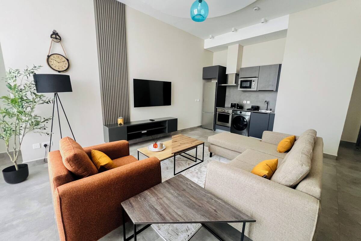 Ein modernes Wohnzimmer mit einer Couch, einem Couchtisch und einem Fernseher.
