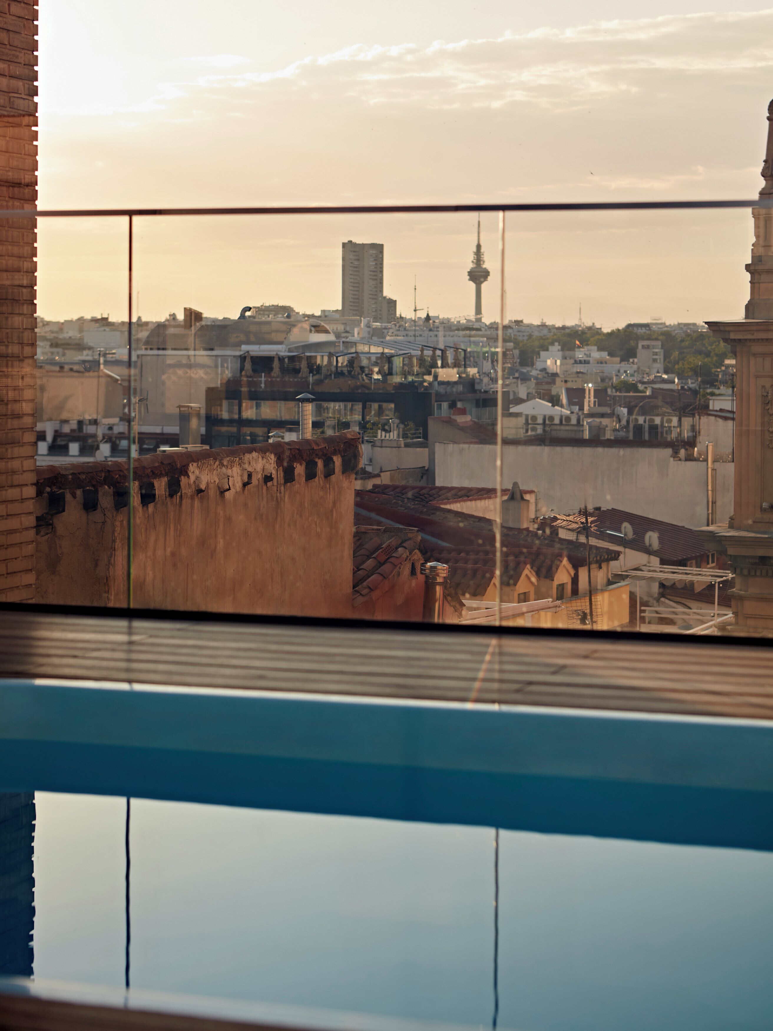 A view from a window overlooking a cityscape with buildings and a tower.