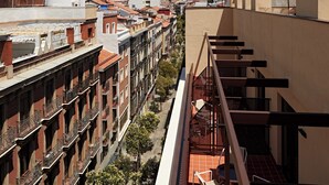 Un edificio de gran altura con múltiples balcones, cielo despejado y un paisaje urbano al fondo.