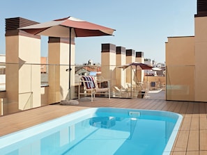 Una piscina al aire libre de temporada, sillones reclinables de piscina