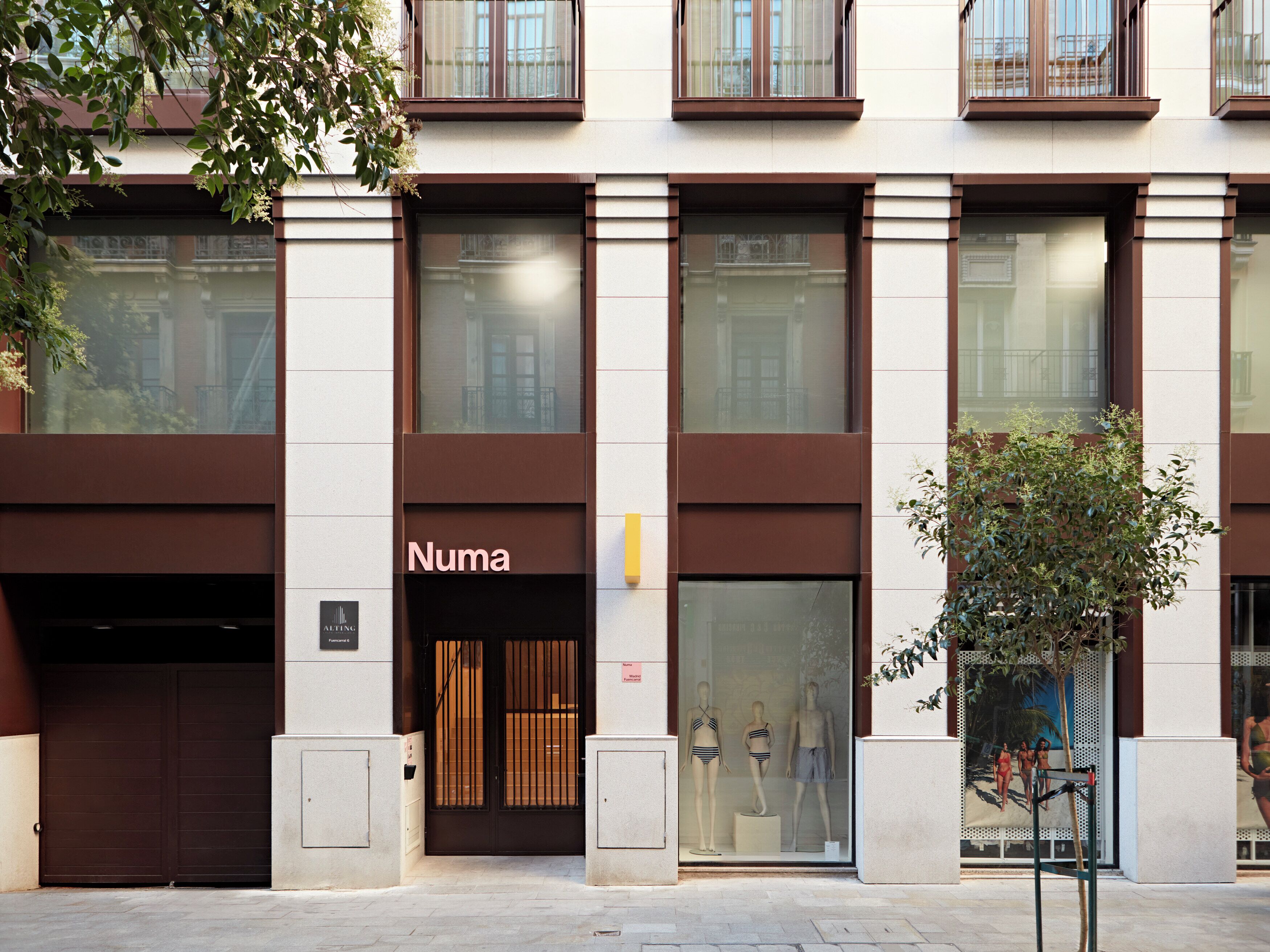 Um edifício com fachada identificada por 'Numa' e vitrine com manequins.