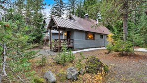Eine Holzhütte mit Metalldach, einer Holzterrasse und einer kleinen Veranda.