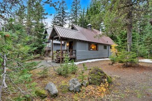 A cabin with a metal roof, wooden deck, and a small porch. - Berghuttlein Getaway - Cozy family retreat w creek (Government Camp)