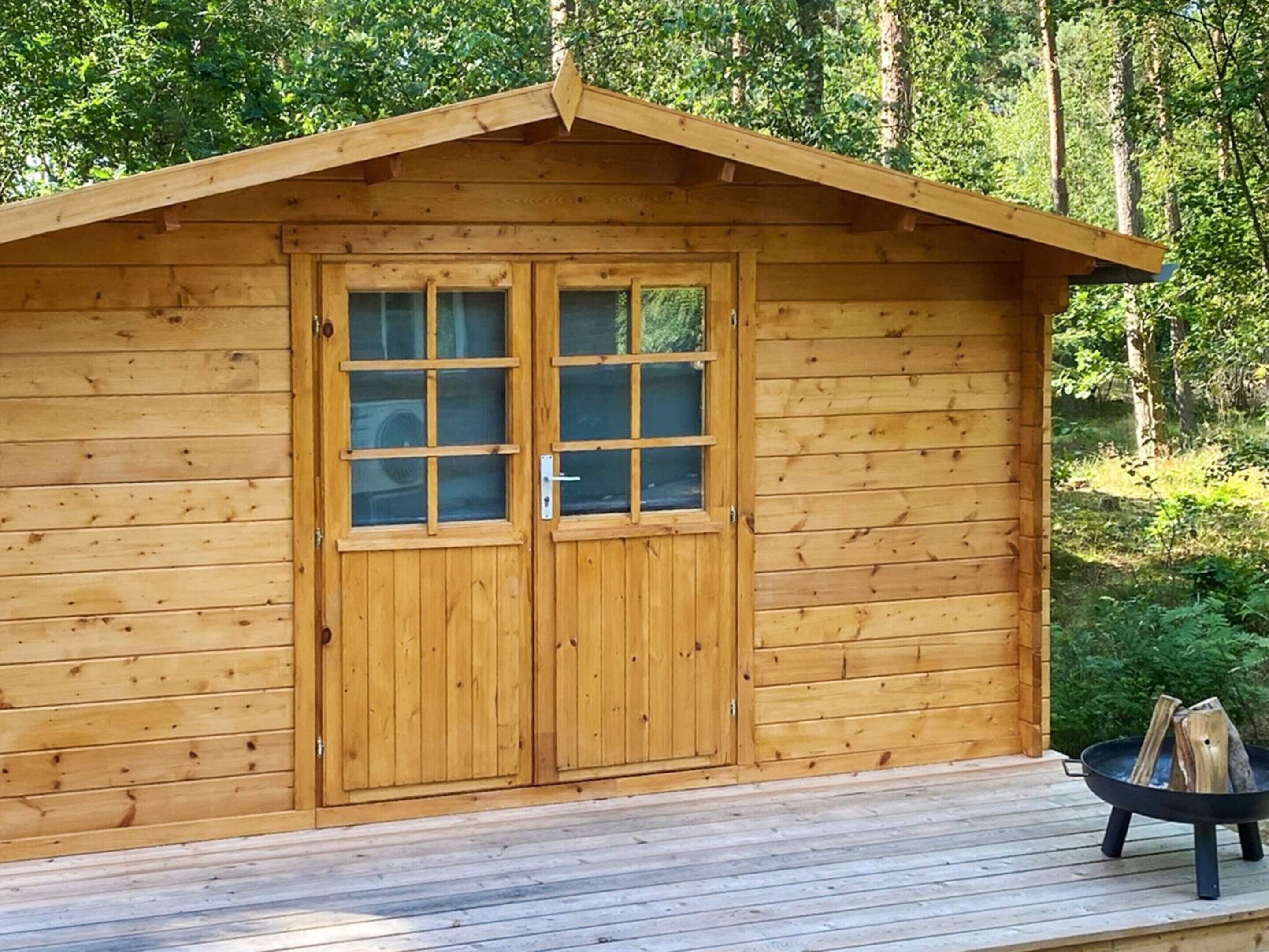 Una baita di legno con una porta doppia e un piccolo portico.