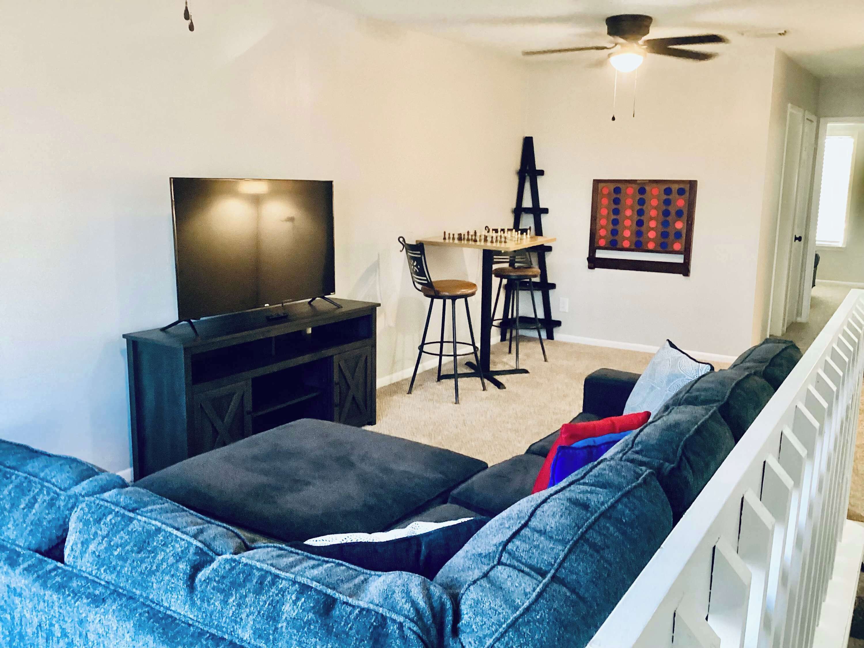 A living room with a TV, a chess table, and a crib.