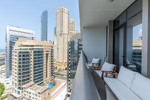A balcony with a view of modern high-rise buildings and a pool. - Glamorous 1BR at Sparkle Tower (Dubai)